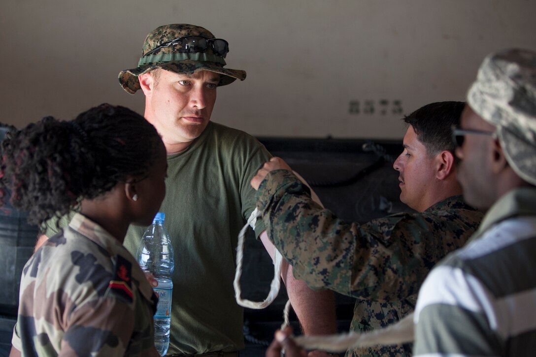 U.S. Navy Hospital Corpsman 1st Class Eric Ancheta, Special-Purpose Marine Air-Ground Task Force Africa 13 corpsman, demonstrates how to apply an improvised tourniquet on Chief Hospital Corpsman Christopher Yaras, Special-Purpose MAGTF Africa 13 corpsman from Austin, Pa., at Bel-Air military base in Dakar, Senegal, April 15, 2013. Marines and Sailors with Special-Purpose MAGTF Africa 13 were recently in Senegal working with Companie de Fusilier Marine Commandos on combat marksmanship, maritime security and light infantry operations. Special-Purpose MAGTF Africa strengthens U.S. Marine Corps Forces Africa and U.S. Africa Command's ability to assist partner nations. The approximately 150 U.S. Marines and Sailors conduct security force assistance, military-to-military engagements and are trained to provide support to crisis response. 