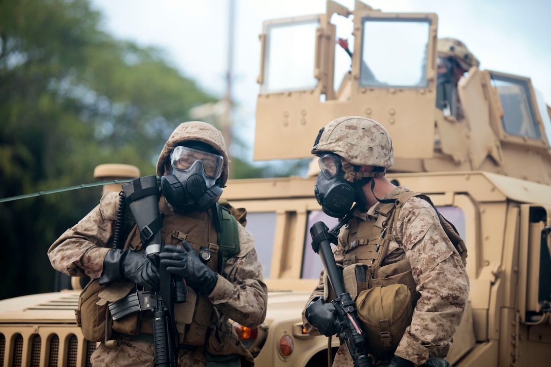 U.S. Marines with Combat Logistics Battalion Three (CLB-3), discuss a plan to infiltrate a city and recover injured role players after a fake chemical improvised explosive device was detonated during a humanitarian assistance disaster relief operation at Marine Corps Training Area Belllows on May 15th, 2013. The operation was in conjunction with chemical, biological, radiological, and nuclear (CBRN) training as part of CLB-3's battalion final exercise. 
