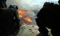 Crew members aboard a MH-60s Seahawk helicopter activate a release button, dumping 420 gallons of water below them on a burning target.  HSC-85 has teamed up with the San Diego California Department of Forestry and Fire Protection to put out the wild fires blazing across Southern California.          