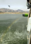 An MH-60S "Knighthawk" from Helicopter Sea Combat Squadron (HSC) 85, the "High Rollers" lifts a full 420-gallon capacity extinguishing trough today from a local resevoir as another MH-60S flies up to fill their trough.

The trough allows massive amounts of water to be dumped on San Diego's ongoing fiery disaster that has already forced more than 250,000 people from their homes across the San Diego county.


