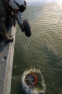 Aviation Warfare Systems Specialist 3rd Class Zach Sykora, attached to Helicopter Sea Combat Squadron Eight Five (HSC) 85, uses a winch to dunk a 420 gallon “Bambi Bucket” in a reservoir.  HSC-85 has teamed up with the San Diego California Department of Forestry and Fire Protection to put out the wild fires blazing across Southern California.      