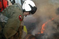 Chief Aviation Electronics Mate (AW/NAC) Rexford Sackett from the "High Rollers" of Helicopter Sea Combat (HSC) Squadron 85 looks from a MH-60S Knighthawk upon miles of burnt terrain along the San Diego County as he and other Sailors from HSC-85 prepare to help fend off the blaze.

The High Rollers provided two MH-60S each specially equiped with a 420 gallon-capacity extinguishing trough used to dump massive amounts of water on San Diego's ongoing fire disaster. 

The dangerous blaze has already forced more than 250,000 people from their homes.

