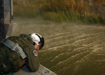 Aviation Warfare Systems Operator 3rd Class (NAC) William Quadrino from the "High Rollers" of Helicopter Sea Combat Squadron (HSC) 85 monitors the altitude of a Navy MH-60S "Seahawk" Tuesday that was specially equipped with a 420-gallon capacity Bambi bucket as it is filled with water.

The High Rollers flew two MH-60S each specially equipped with a 420-gallon capacity Bambi bucket used to drop water in coordination with civillian fire fighters. 

