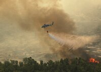 A Navy MH-60S "Seahawk" from the "High Rollers" of Helictoper Sea Combat Squadron (HSC) 85 drops water from a 420-gallon capacity Bambi bucket Tuesday in coordination with civillian fire fighters. 

HSC-85 flew two MH-60S each specially equipped with a Bambi bucket.

