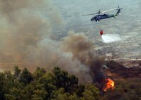 A Navy MH-60S "Seahawk" from the "High Rollers" of Helictoper Sea Combat Squadron (HSC) 85 drops water from a 420-gallon capacity Bambi bucket Tuesday in coordination with civillian fire fighters.

HSC-85 flew two MH-60S each specially equipped with a Bambi bucket.

