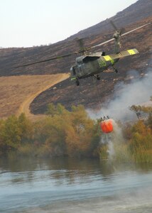 A Navy MH-60S "Seahawk" from the "High Rollers" of Helictoper Sea Combat Squadron (HSC) 85 lifts to the air after fillingl a 420-gallon capacity Bambi bucket Tuesday used to drop water in coordination with civillian fire fighters. 

HSC-85 flew two MH-60S each specially equipped with a Bambi bucket.

U.S. Navy photo by Mass Communication Specialist 2nd Class (SW/AW) Chris Fahey.
