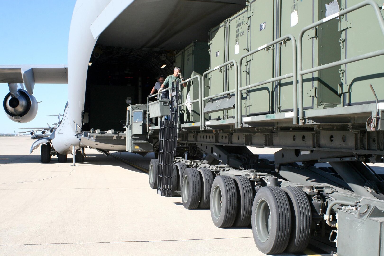 Aircraft freight loaders move containers belonging to a U.S. Army North operational command post onto a C-17 at Kelly USA, in San Antonio, Tex. Oct. 24th.  The OCP is deploying in response to the effort to fight the wildfires burning in Calif.