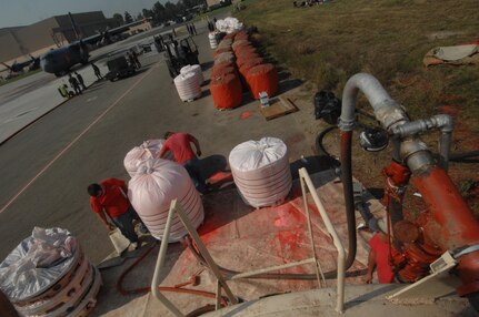 Civilians from the PHOS CHECK Air Attack Team, control the mixture of fire retardant powder being emptied out from it's bin in preparation for loading the mixture on to a C-130 as it prepares to launch from Channel Islands Air National Guard Station, Calif., on Oct. 25, 2007 in support of the California firefighting efforts. The U.S. Air Force Reserve and Air National Guard are participating in the Southern California firefighting effort. 