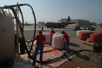 Civilians from the PHOS CHECK Air Attack Team, control the mixture of fire retardant powder being emptied out from it's bin in preparation for loading the mixture on to a C-130 as it prepares to launch from Channel Islands Air National Guard Station, Calif., on Oct. 25, 2007 in support of the California firefighting efforts. The U.S. Air Force Reserve and Air National Guard are participating in the Southern California firefighting effort. 