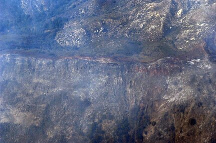 Fire retardant lines are placed in front of the advancing Poomacha fire burning in the Mount Palomar area. C-130s launched from Channel Islands Air National Guard Station, Calif., Oct., 26, 2007 are participating in the Southern California firefighting effort. 