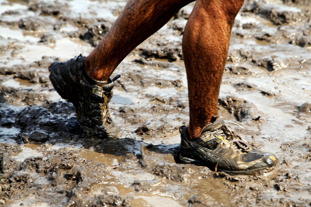 A runner jogs through a mud pit at the end of an obstacle during the 20th Anniversary World Famous Mud Run held at the 26 and 27-areas here June 1. The World Famous Mud Run is a ten-kilometer race with seven obstacles that can be run individually or in teams. 