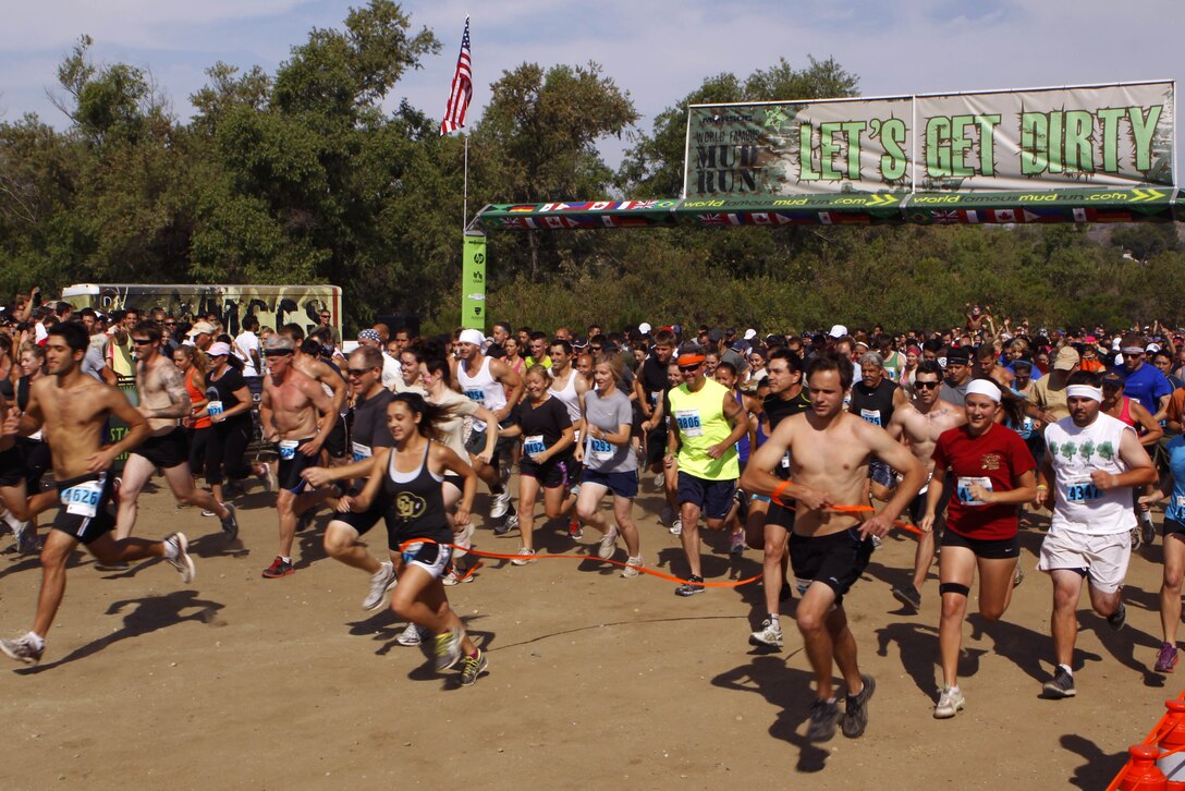 Competitors charge through the starting line of the 20th annual World Famous Mud Run here June 1. Several obstacles were incorporated into the 10K, which started at Lake O’Neil, and took the runners through training areas 26 and 27 of the base.