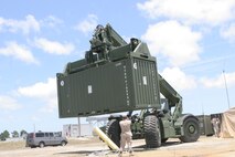 Marines from II Marine Expeditionary Force ground-guide a Kalmar carrying an intermodal container on a Florida beach during a Marine Prepositioning Force Exercise aboard Marine Corps Support Facility Blount Island, Fla., May 27, 2013. The exercise was to familiarize Marines with prepositioning in preparation for a larger exercise scheduled to take place next year. (U.S. Marine Corps photo by Lance Cpl. Shawn Valosin)
