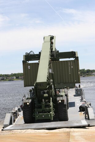 A Kalmar unloads an intermodal container from a Navy lighterage vessel during a Marine Prepositioning Force Exercise aboard Marine Corps Support Facility Blount Island, Fla., May 26, 2013. The exercise was conducted by service members from the II Marine Expeditionary Force in conjunction with sailors from Navy Beach Master Unit Two, based at Naval Amphibious Base Little Creek, Va.  (U.S. Marine Corps photo by Lance Cpl. Shawn Valosin)