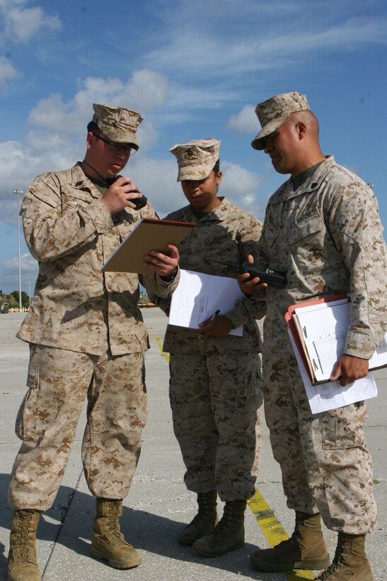 Hospital Corpsman Alex Peeler (left), from 2nd Medical Battalion, 2nd Marine Logistics Group, and service members from II Marine Expeditionary Force call in vehicle movements over a radio during a Marine Prepositioning Force Exercise aboard Marine Corps Support Facility Blount Island, Fla., May 28, 2013. During the exercise Peeler worked with Marines, learning more about their individual mission in the MPF. (U.S. Marine Corps photo by Lance Cpl. Shawn Valosin)