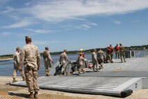 Service members from II Marine Expeditionary Force board a navy lighterage vessel during a Marine Prepositioning Force exercise conducted aboard Marine Corps Support Facility Blount Island, Fla., May 25, 2013. Sailors from Beach Master Unit Two showed the II MEF service members various areas of the vessel and how it worked. (U.S. Marine Corps photo by Lance Cpl. Shawn Valosin)