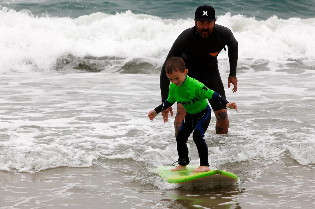 Surfer Mitch Abshere teaches 4-year-old Noah, the basics of how to stand on a surfboard during the Hurley surf event held at Del Mar Beach Resort here June 2. Hurley’s summer surf tour travels around the country to give children an opportunity to learn from and ride with professional surfers. Abshere is a professional surfer who rides for the Hurley surf team and the owner of Captain Helm surf shop, the Captain Fin Co., and the wetsuit company Sea Vessel. 