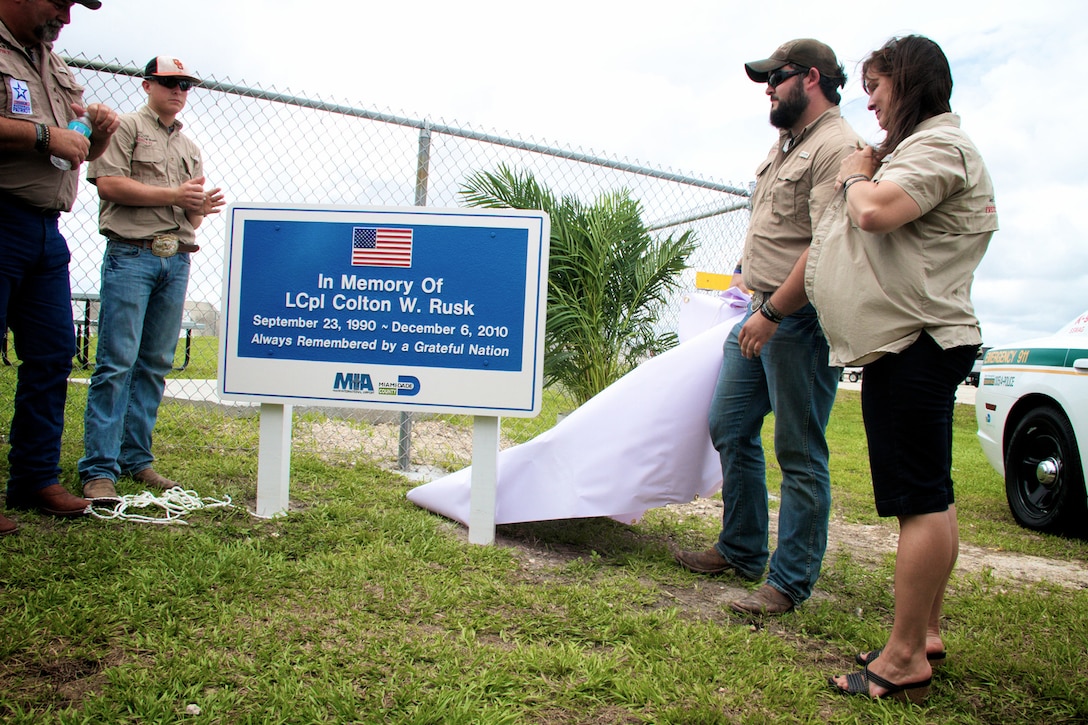 Marine Lance Cpl. Colton Rusk’s family unveils a sign honoring Rusk’s service during a dedication ceremony at Miami International Airport May 31, 2013. Miami-Dade Police and the Transportation Security Administration memorialized Rusk, who was killed by a sniper while serving in Afghanistan as a dog handler, by naming their new canine training center in his memory. County officials also issued a proclamation making the Rusk family honorary residents of Miami-Dade County.
