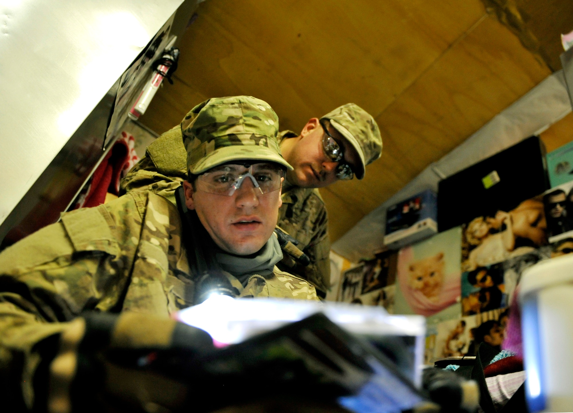 Tech. Sgt. Michael Taylor and Staff Sgt. Darren Looze, Task Force Colonist volunteers search a third country national employee’s room for unauthorized items on Bagram Airfield, Afghanistan, May 30. Task Force Colonist is force protection tool used to conduct random camp sweeps of other third country national employee living quarters for illegal items such as drugs, weapons, unauthorized uniform items, and/or electronic devices.  This program was created to increase preventative measures on base and to help stop something before it happens. Both members are deployed from Moody Air Force Base, Ga. (U.S. Air Force photo/ Staff Sgt. Stephenie Wade)