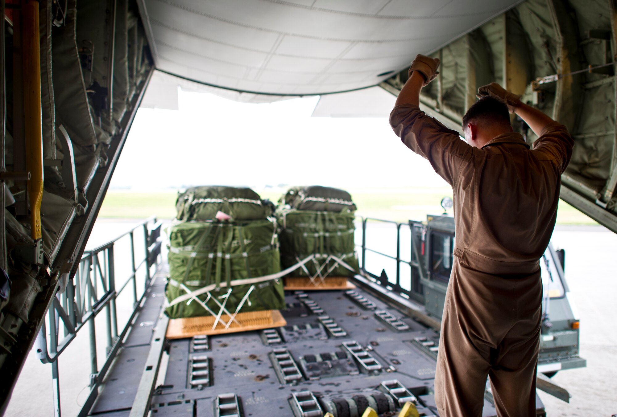 YOKOTA AIR BASE, Japan -- Cpl. Brook Cannon, loadmaster with Marine Airlift Group 36, Iwakuni, Japan, guides a Halverson 25K loader carrying low velocity container delivery system bundles to the back of a C-130 at Yokota Air Base, Japan May 29, 2013. Cannon along with other members from joint services are at Yokota for Airborne Tomahawk, a training exercise to evaluate rigging and movement procedures and execute airdrop resupply. (U.S. Air Force photo by Staff Sgt. Stacy Moless)  