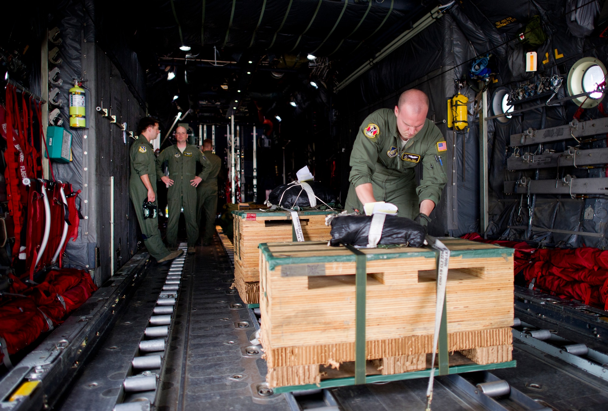 YOKOTA AIR BASE, Japan -- Senior Airman Noel Jones, loadmaster with the 36th Airlift Squadron, secures the low cost low altitude bundle to a C-130 aircraft floor to ensure it remains in position during the flight May 29, 2013 at Yokota Air Base, Japan. The bundles will be released from a C-130 during exercise Airborne Tomahawk, a training exercise with joint services. (U.S. Air Force photo by Staff Sgt. Stacy Moless)  