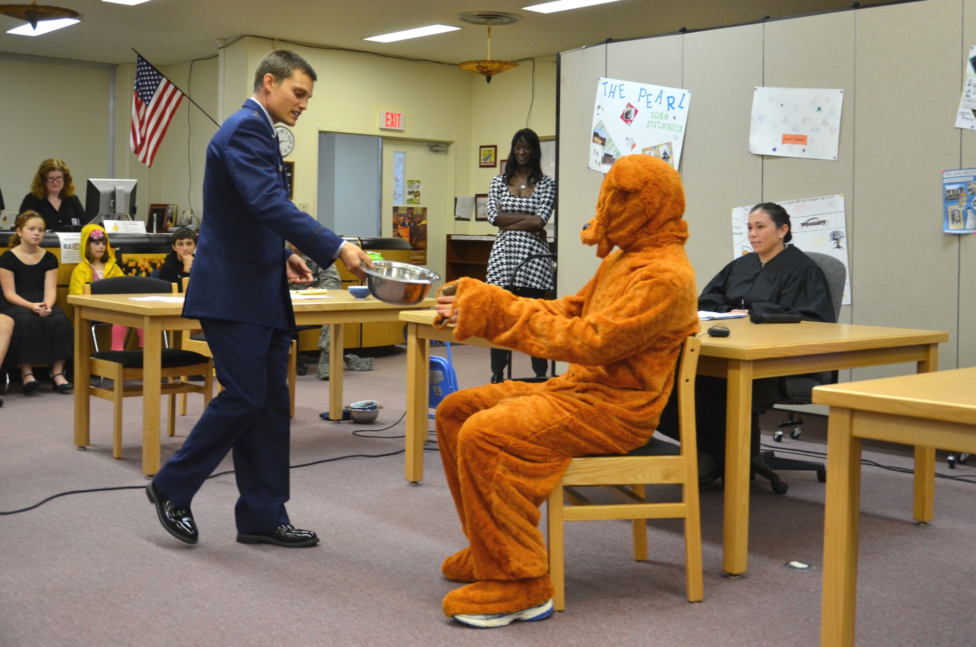 U.S. Air Force 1st Lt. Josh Austin, 18th Wing judge advocate, as prosecutor introduces Papa Bear’s, played by Capt. Konrad Osa, 18th Wing judge advocate, porridge bowl as evidence during a mock trial at Kadena Middle School on Kadena Air Base, Japan, May 23, 2013.  U.S. Air Force Lt. Col. Taralyn Olayvar, 18th Wing deputy staff judge advocate, presided as judge as KMS students served as jurors and teachers observed. (U.S. Air Force photo by Senior Master Sgt. Daniel Kazumura/Released)