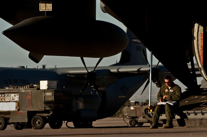 U.S. Air Force Tech. Sgt. Bob Coyne, 29th Weapons Squadron loadmaster, Little Rock Air Force Base, Ark., writes in his flight book on the ramp of a C-130 Hercules before taking part in a Joint Forcible Entry exercise May 31, 2013, at Nellis Air Force Base, Nev. Coyne logs the weight and position of equipment in his flight book to ensure the plane is properly balanced. (U.S. Air Force photo by Senior Airman Daniel Hughes)