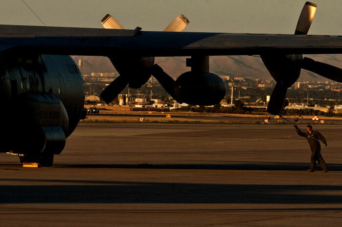 U.S. Air Force Airman 1st Class Cory Lehr, 192nd Airlift Squadron loadmaster, Nevada Air National Guard, removes the intake covers from a C-130 Hercules before taking part in a Joint Forcible Entry exercise May 31, 2013, at Nellis Air Force Base, Nev. The intake covers help protect the engines against foreign objects entering when not in flight. (U.S. Air Force photo by Senior Airman Daniel Hughes)