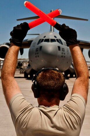 U.S. Air Force Senior Airman Jeremy Soyke, 62nd Maintenance Squadron crew chief from McChord Air Force Base, Wash., marshals a C-17 Globemaster III after finishing a Joint Forcible Entry Exercise May 31, 2013, at Nellis Air Force Base, Nev. Crew chiefs are responsible for parking jets precisely on their row and spot. (U.S. Air Force photo by Senior Airman Daniel Hughes)