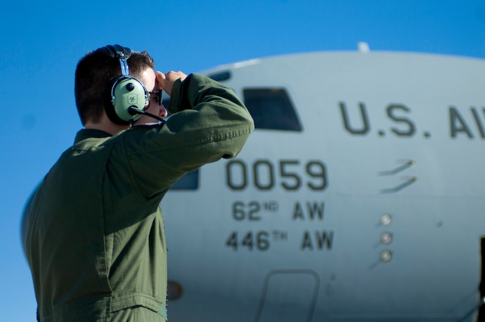 Staff Sgt. Steven Doubler, a loadmaster with the 62nd Airlift Wing, Joint Base Lewis-McChord, Wash., assists the pilot in pre-flight checks May 31, at Nellis Air Force Base Nev. A loadmaster's duties include mathematically pre-planning the correct placement of the load on the airplane, providing passenger comfort and safety, securing cargo and taking part in airdrop operations. (U.S. Air Force photo by Airman 1st Class Joshua Kleinholz)
