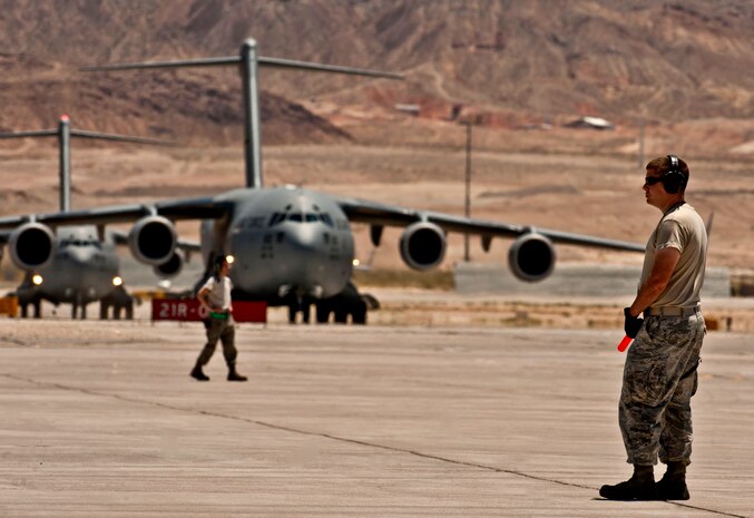 U.S. Air Force Senior Airman Jeremy Soyke, 62nd Maintenance Squadron crew chief from McChord Air Force Base, Wash., marshals a C-17 Globemaster III after finishing a Joint Forcible Entry Exercise May 31, 2013, at Nellis Air Force Base, Nev. Squadrons from bases across the country came to Nellis to participate in the JFEX. (U.S. Air Force photo by Senior Airman Daniel Hughes)