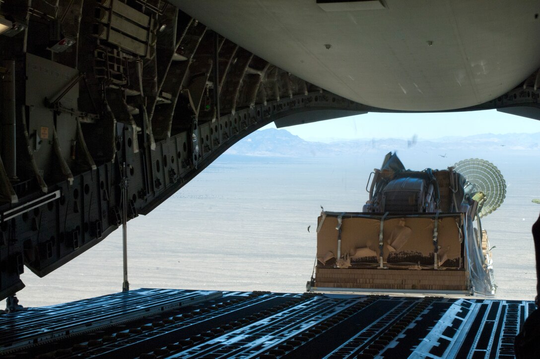 A piece of heavy land-moving equipment is dropped out of the back of a C-17 Globemaster III May 31, over the Nevada Test and Training Range. As part of the Joint Forcible Entry exercise, heavy equipment was dropped into simulated-contested drop zones to assist forces on the ground. (U.S. Air Force photo by Airman 1st Class Joshua Kleinholz)