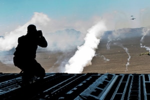 Senior Airman Brett Clashman, 99th Air Base Wing Public Affairs photojournalist, takes photos from the back of a C-17 Globemaster III during the Joint Forcible Entry exercise May 31 over the Nevada Test and Training Range. During the exercise, C-17s dropped service members and heavy equipment into simulated contested drop zones. (U.S. Air Force photo by Airman 1st Class Joshua Kleinholz)