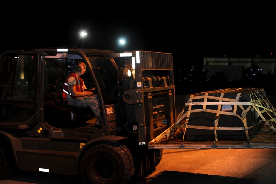 U.S. Air Force Airman 1st Class Kevin Nigh, 18th Logistics Readiness Squadron vehicle maintenance technician, takes a pallet to be measured and weighed during a training scenario on Kadena Air Base, Japan, June 4, 2013. Training scenarios keep Airmen proficient and prepare them for possible real-world situations. (U.S. Air Force photo by Airman 1st Class Justin Veazie/Released)