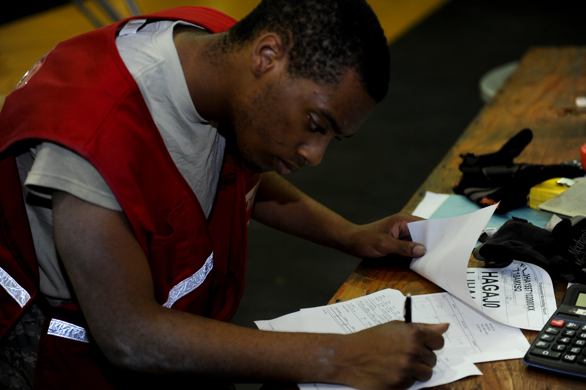 U.S. Air Force Airman 1st Class Chauncey Ward, 18th Logistics Readiness Squadron fuels operator, records the height and weight of a B-5 maintenance platform during a training scenario on Kadena Air Base, Japan, June 4, 2013.  Different scenarios like these build skills Airmen need if they encounter a real-world emergency. (U.S. Air Force photo by Airman 1st Class Justin Veazie/Released)