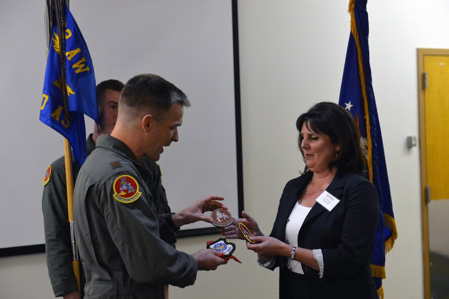 Maj. Scott Wiederholt, 10th Airlift Squadron director of operations, presents patches to the 10th AS's new honorary commander, Jaimie Garrett, Cobalt Mortgage senior loan officer, May 31, 2013 at Joint Base Lewis-McChord, Wash. (U.S. Air Force photo/Staff Sgt. Jason Truskowski)