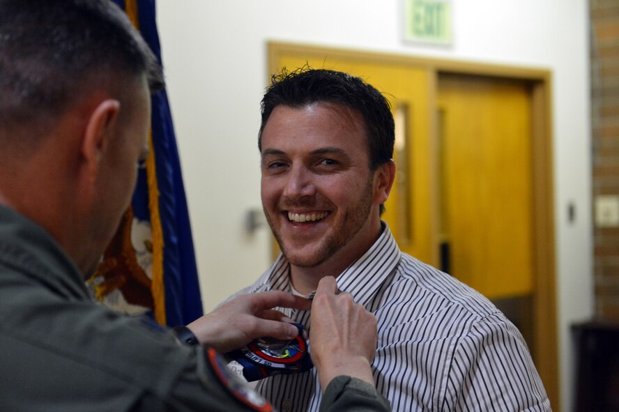 Lt. Col. Thomas O'Connell, 4th Airlift Squadron commander (left), fastens a commanders' insignia pin on the 4th AS's new honorary commander, Devin Craig, Starbucks district manager, May 31, 2013 at Joint Base Lewis-McChord, Wash. Craig was one of seven community leaders inducted as new honorary commanders. (U.S. Air Force photo/Staff Sgt. Jason Truskowski)