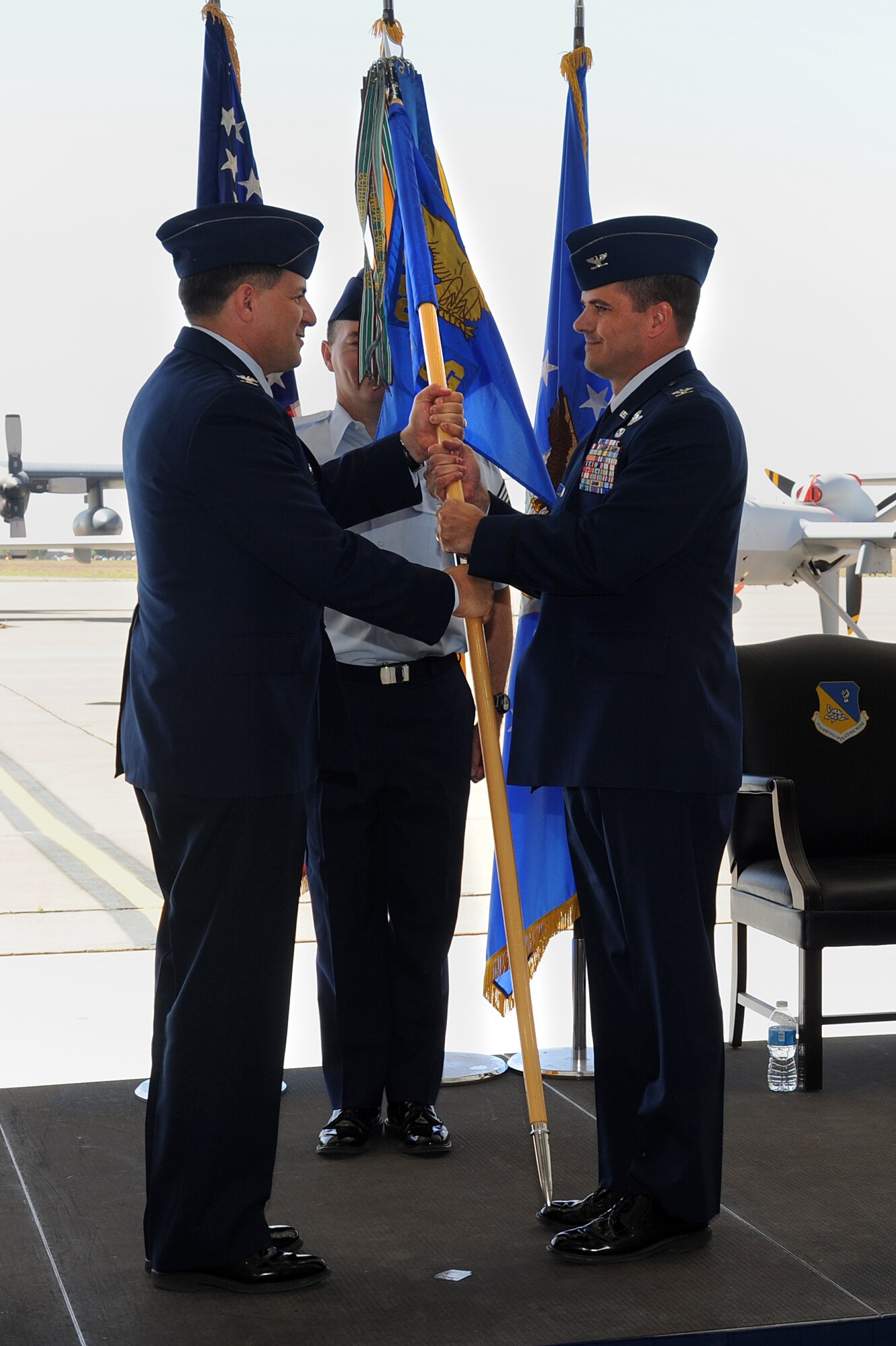 U.S. Air Force Col. Buck Elton, 27th Special Operations Wing commander, passes the guidon to Col. Sean Farrell, 27th Special Operations Group commander, during a change of command ceremony at Cannon Air Force Base, N.M., May 31, 2013.  Elton presided over the ceremony, in which Col. William West relinquished command of the 27 SOG to Farrell.  (U.S. Air Force photo/Senior Airman Jette Carr)