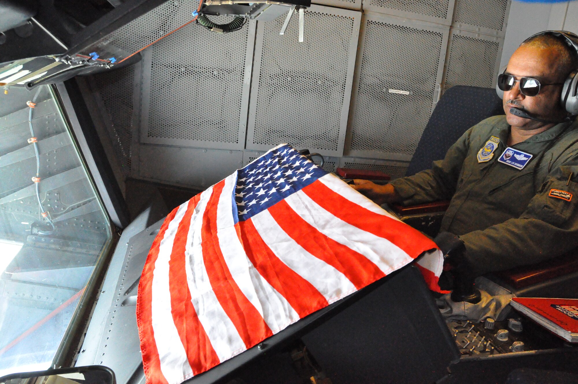 Chief Master Sgt. Luis Drummond, 60th Operations Group superintendent, shows his flag that has flown with him all over the world throughout his 10,000 hours as a boom operator.  (U.S. Air Force Photo/2nd Lt. Jessica Clark)