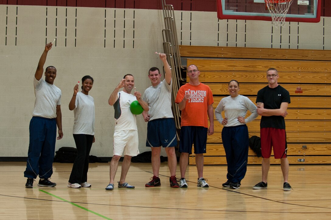 The 28th Maintenance Squadron Aerospace Ground Equipment section Airmen hoist their first-place prizes after winning a lunchtime dodgeball tournament at the Bellamy Fitness Center on Ellsworth Air Force Base, S.D., May 21, 2013. The winning team received lollipops for their victory in the tournament as part of fitness month. (U.S. Air Force photo by Airman 1st Class Alystria Maurer/Released)
