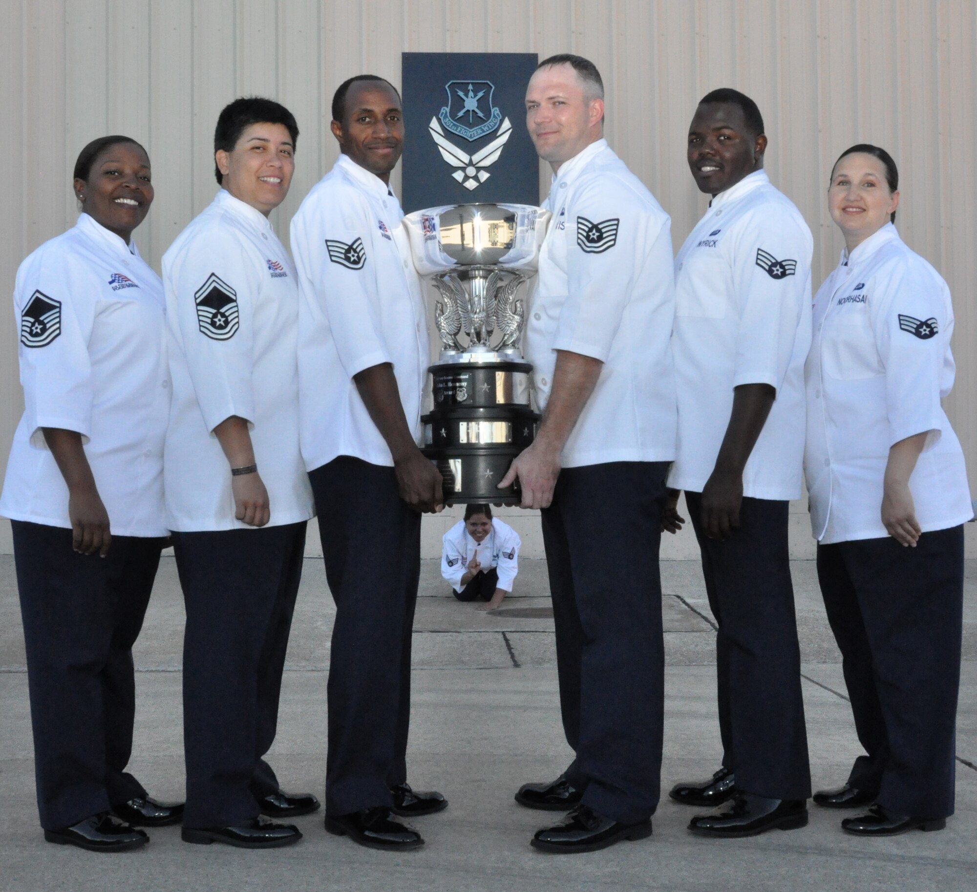 The 301st Sustainment Services Flight food services team won the 2013 John L. Hennessey Trophy Award competition for the Air Force Reserve Command. The Hennessy competition is in its 57th year but this year marks the first Hennessy win for the 301st. From left to right, Master Sgt. Trika Bunkley, Senior Master Sgt. Grace Vargas, Staff Sgt. Robert Hughes, (under the trophy) Senior Airman Selina Saene-Valdez, Tech. Sgt. Stephen Davis, Senior Airman Brandon Wyrick and Senior Airman Monica Noorhasan. Also on the team but not pictured are Senior Airmen Angel Agosto and Lescotcia Smith. (U.S. Air Force photo/Master Sgt. Julie Briden-Garcia)