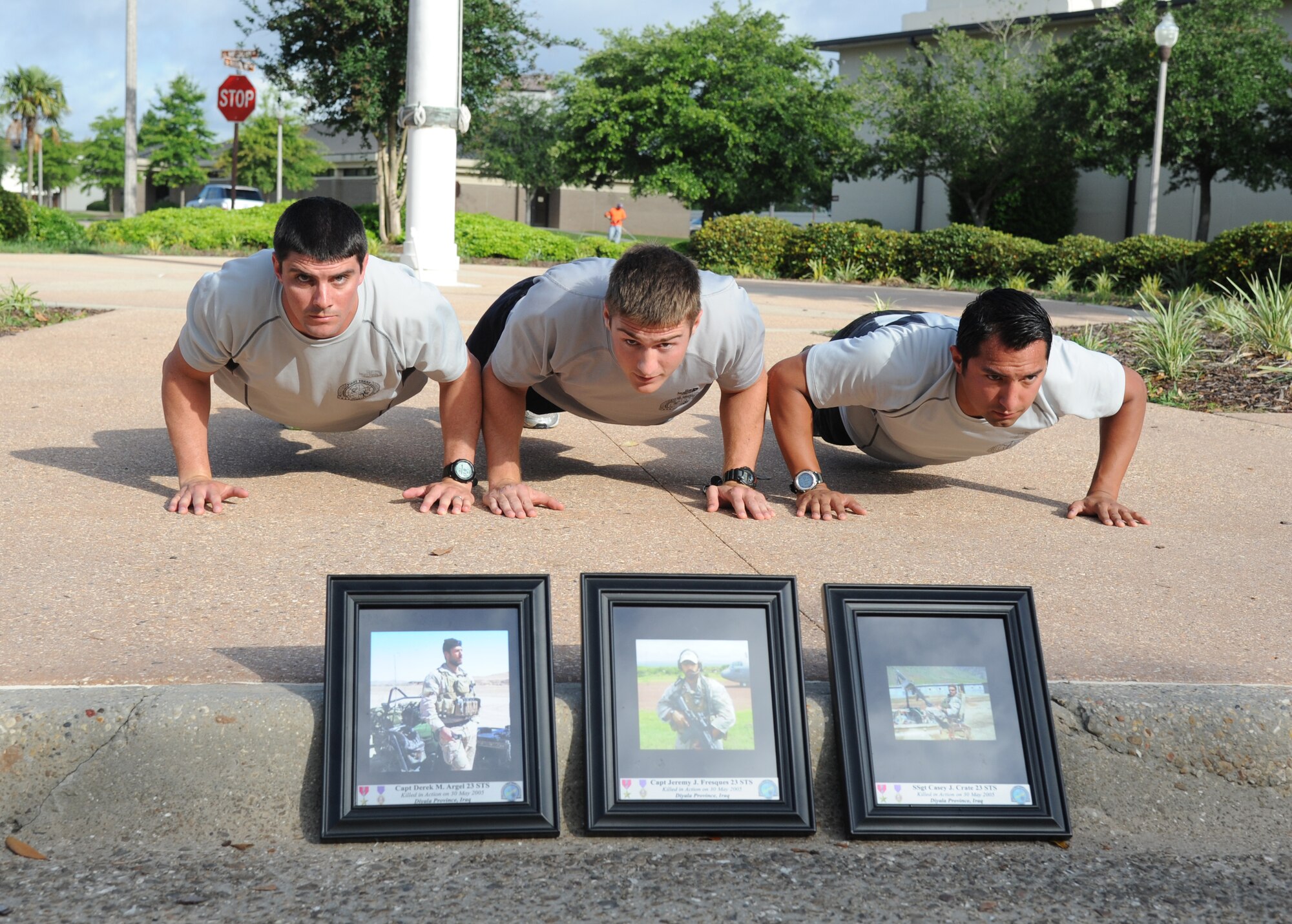 Staff Sgts. Timothy Bonne and Bryan Etzler, 334th Training Squadron combat controller instructors, and Joey Cidillo, 335th Training Squadron special operations weather instructor, do push-ups as they conclude a memorial physical training session May 31, 2013, at Keesler Air Force Base, Miss.  The three-day PT event was in memory of three combat controllers who lost their lives on Memorial Day 2005 in Iraq.  (U.S. Air Force photo by Kemberly Groue)