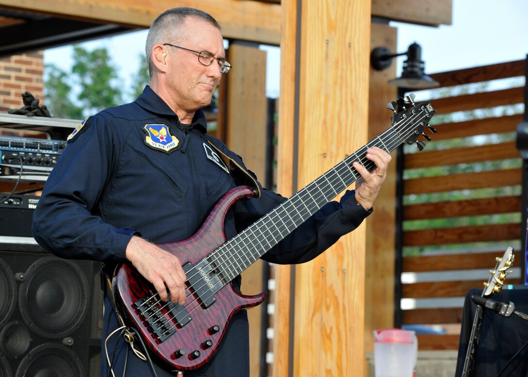 Master Sgt. David Foster, Max Impact electric bass player, performs for a crowd at the USO Warrior and Family Center on Ft. Belvoir, Va., May 22, 2013. Max Impact performed at the newly-opened center in conjunction with a free community-wide barbecue in order to garner awareness of future USO-sponsored events. (U.S. Air Force photo/Senior Airman Lindsey A. Porter)