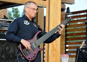 Master Sgt. David Foster, Max Impact electric bass player, performs for a crowd at the USO Warrior and Family Center on Ft. Belvoir, Va., May 22, 2013. Max Impact performed at the newly-opened center in conjunction with a free community-wide barbecue in order to garner awareness of future USO-sponsored events. (U.S. Air Force photo/Senior Airman Lindsey A. Porter)