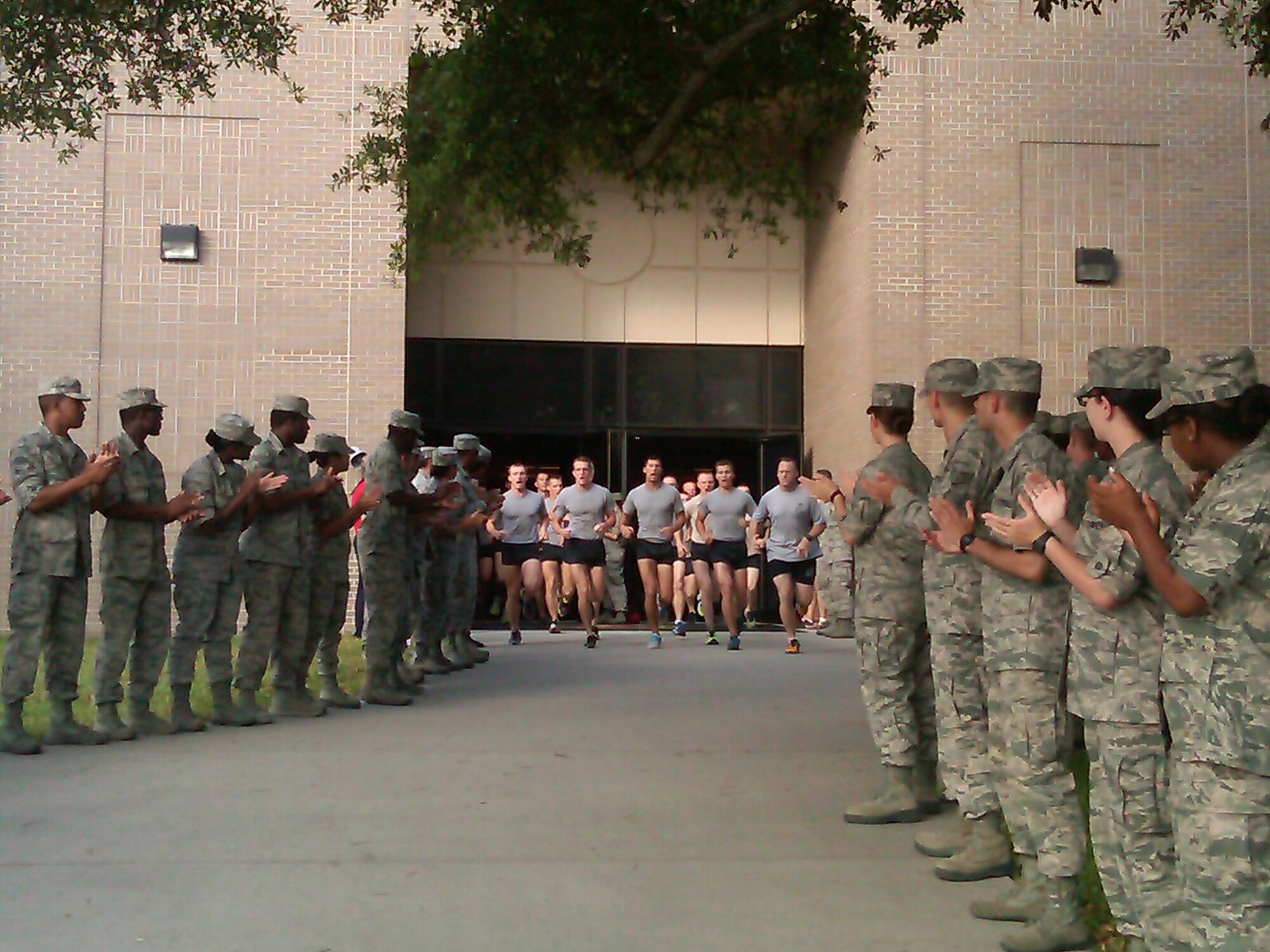 Airmen from the 81st Training Group exit Cody Hall during a memorial physical training session May 31, 2013, at Keesler Air Force Base, Miss.  The three-day PT event was in memory of three combat controllers who lost their lives on Memorial Day 2005 in Iraq.  (U.S. Air Force photo by Lt. Col. Jeffrey McLemore)