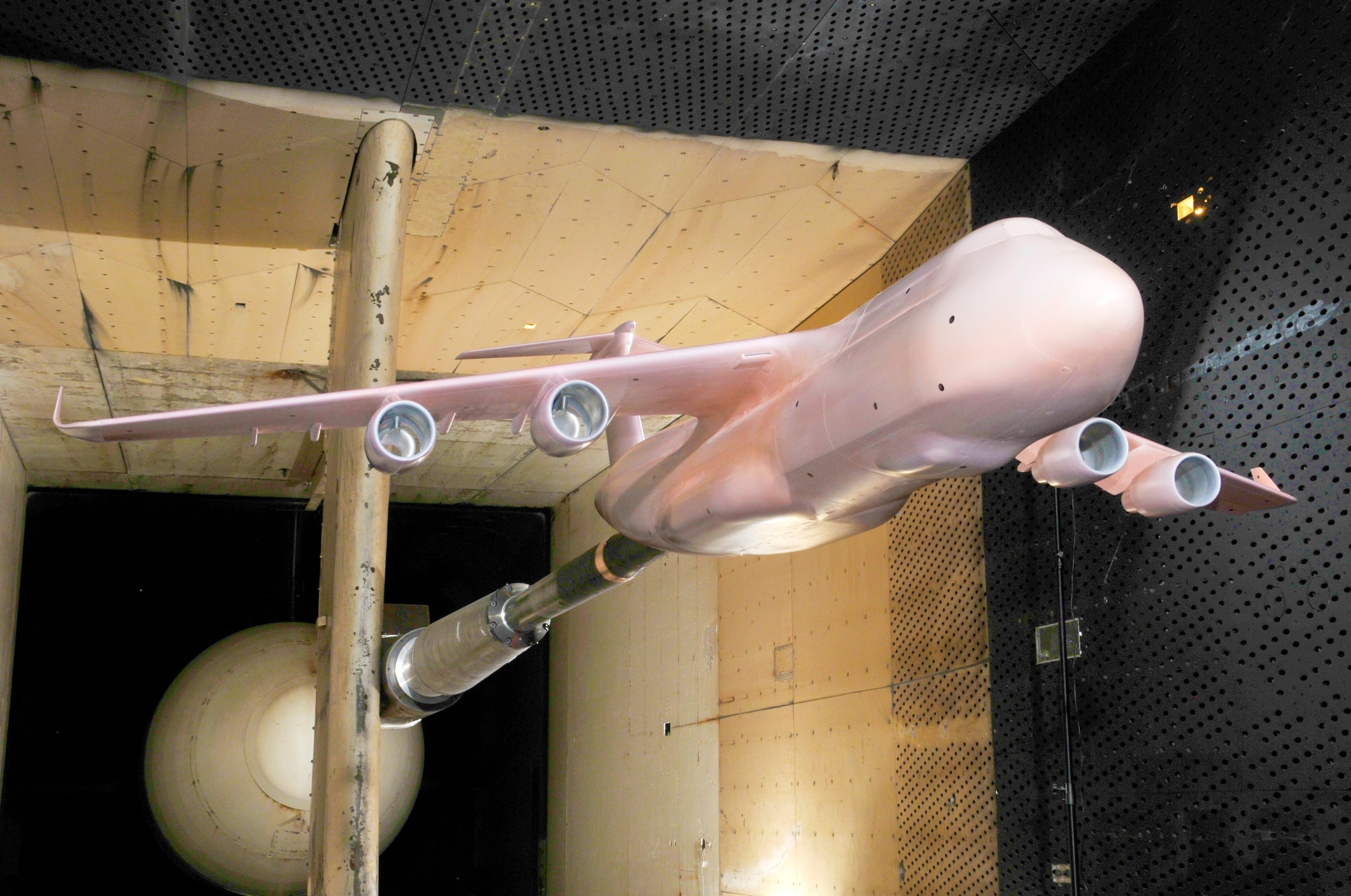 Pictured here is the C-5M Super Galaxy model in Arnold Engineering Development Complex’s (AEDC) 16-foot Transonic Wind Tunnel. The model is a pink color as a result of AEDC’s application of Pressure Sensitive Paint (PSP) before the test was conducted. (Photo by Rick Goodfriend)