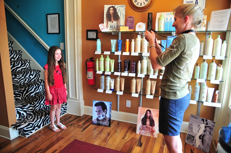 U.S. Air Force Col. Jeannie Leavitt, 4th Fighter Wing commander, takes a picture of her daughter, Shannon, 8, prior to donating her hair at J. L. Eden Salon & Day Spa in Goldsboro, N.C., June 1, 2013. Leavitt said she was proud of her daughter for showing selflessness by donating 12 inches of her hair to Wigs for kids, a non-profit organization benefiting children who suffer from hair loss due to medical conditions. (U.S. Air Force photo by Airman 1st Class Aubrey White/Released)