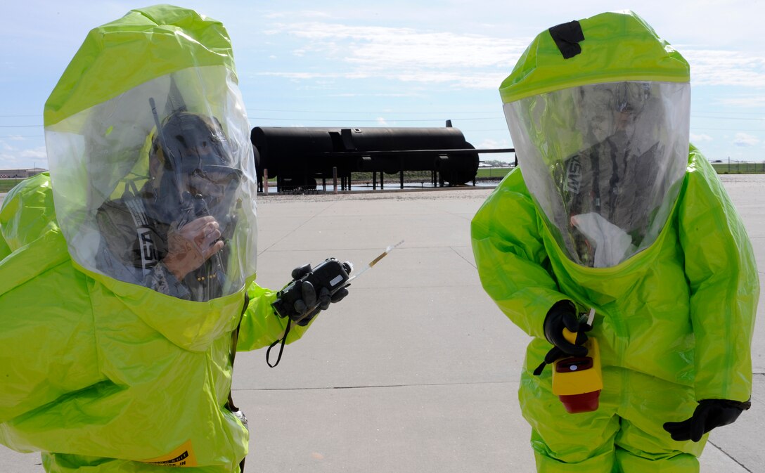 Airman 1st Class Jessica Gluth (left), 28th Civil Engineer Squadron emergency management technician, and Senior Airman Roger Pedraza, 28th Medical Operations Squadron bioenvironmental engineering technician, relay information about a simulated hazardous material spill to the mobile emergency operations center during a training exercise at Ellsworth Air Force Base, S.D., May 23, 2013. The team waited for instructions on how to proceed after notifying the mobile EOC that they had stopped the leak. (U.S. Air Force photo by Airman 1st Class Ashley J. Thum/Released)
