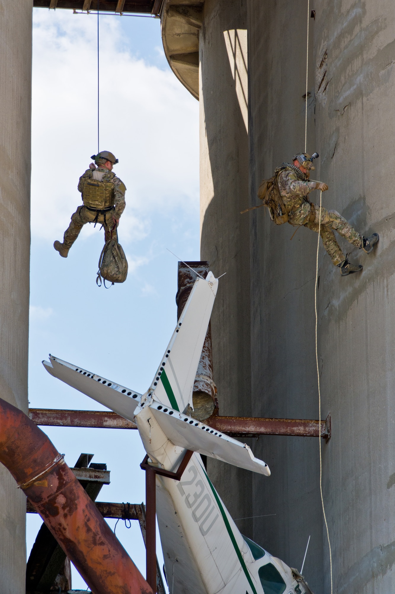 Major David McGraw (left), a Combat Rescue Officer, and SMSgt Robert Bean (right), a Pararescueman, rappel down cement towers to a wrecked airplane.  Photo credit: Mr. Rick Eldridge.