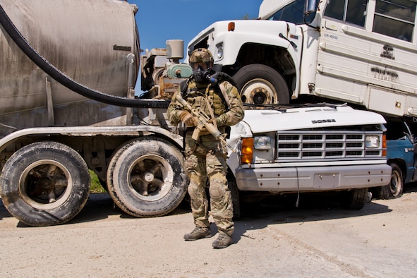 SMSgt Robert Bean (AFLCMC/WI) stands in front of a pile of wreckage vehicles at Calamityville.  Photo credit: Mr. Rick Eldridge.